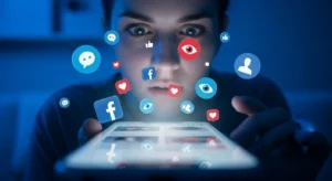 Pessoa olhando para a tela do celular com expressão de surpresa, cercada por ícones flutuantes do Facebook — como curtidas, corações e olhos — iluminada por uma luz azul que simboliza mistério e tecnologia.